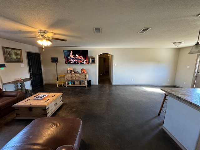 living room featuring a textured ceiling and ceiling fan