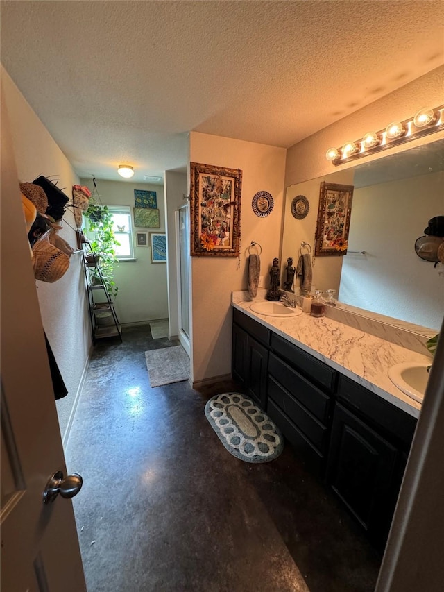 bathroom featuring a textured ceiling, walk in shower, and vanity