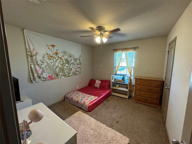 bedroom with a textured ceiling, carpet floors, and ceiling fan