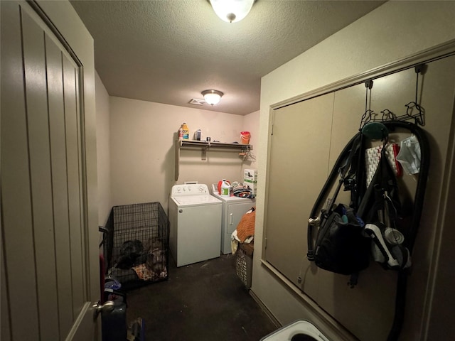 washroom with washing machine and dryer and a textured ceiling