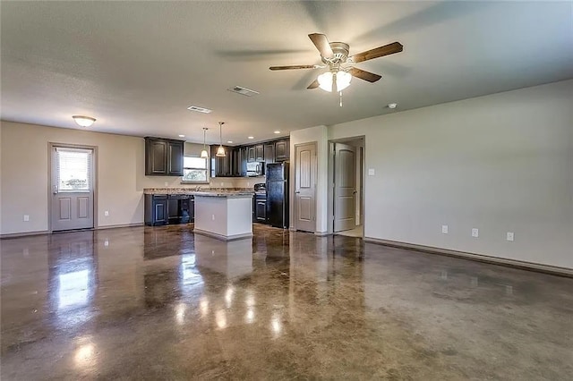 kitchen with a center island, black refrigerator, ceiling fan, hanging light fixtures, and dark brown cabinetry