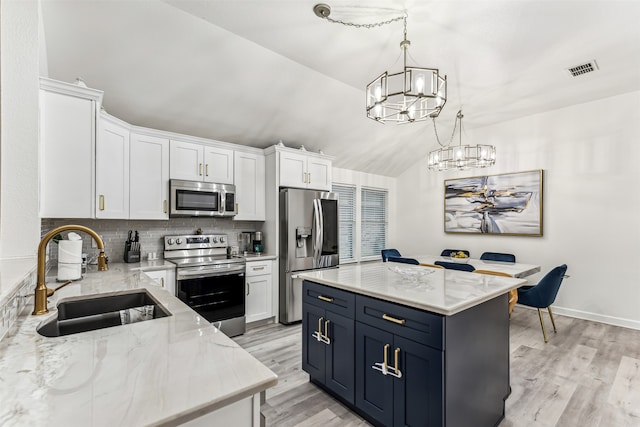 kitchen with a center island, white cabinets, stainless steel appliances, and sink