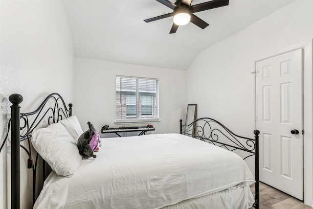 bedroom with ceiling fan, light hardwood / wood-style flooring, and lofted ceiling