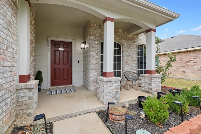 view of exterior entry featuring covered porch