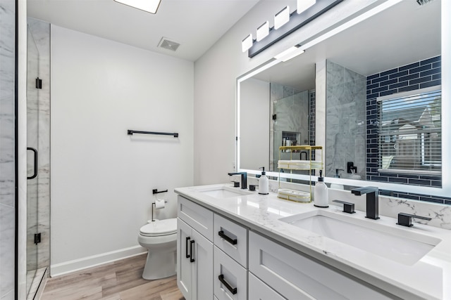 bathroom featuring hardwood / wood-style floors, vanity, toilet, and a shower with door