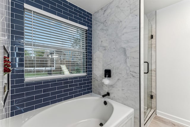 bathroom featuring shower with separate bathtub and hardwood / wood-style flooring