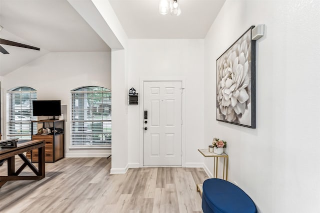 foyer entrance with ceiling fan, lofted ceiling, and light hardwood / wood-style flooring