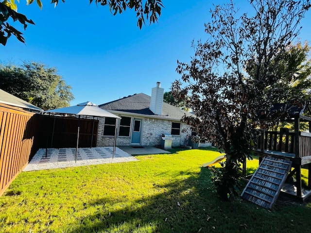 back of house with a patio area and a lawn