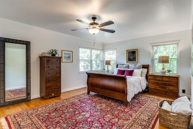 bedroom with light hardwood / wood-style floors, ceiling fan, multiple windows, and ornamental molding