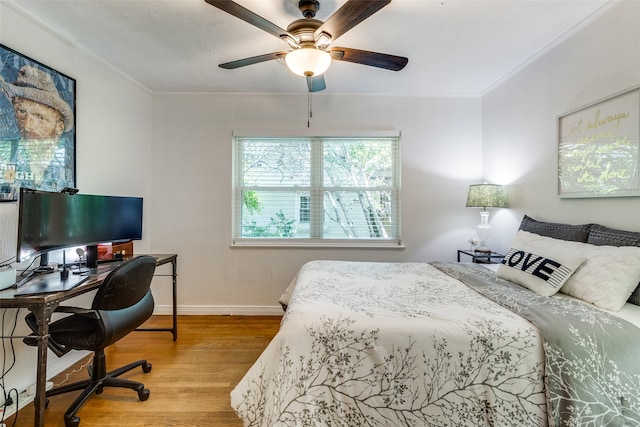 bedroom featuring hardwood / wood-style flooring, ceiling fan, and crown molding