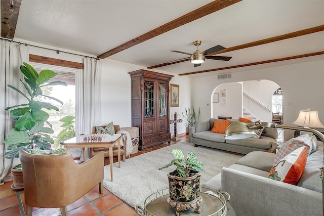 tiled living room featuring beamed ceiling and ceiling fan