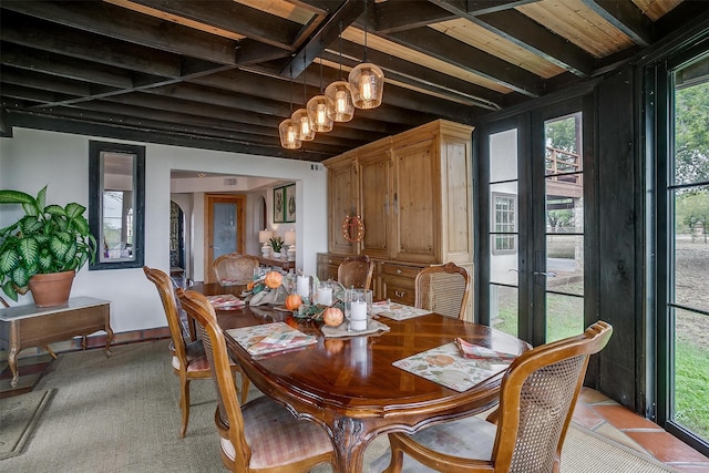 dining space featuring french doors and beam ceiling