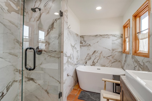 bathroom featuring independent shower and bath, vanity, and tile walls