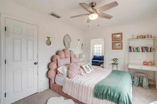 carpeted bedroom featuring ceiling fan and crown molding