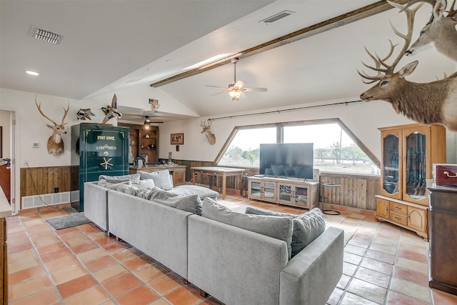 living room featuring lofted ceiling with beams, wood walls, ceiling fan, and light tile patterned floors