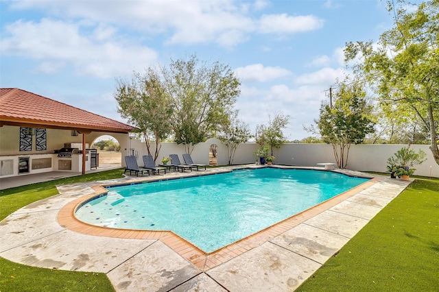 view of swimming pool with a diving board, a patio, and exterior kitchen