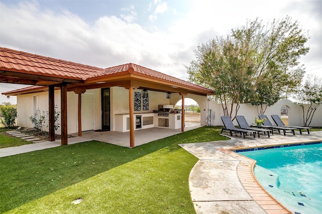 exterior space with a patio, exterior kitchen, a yard, and area for grilling