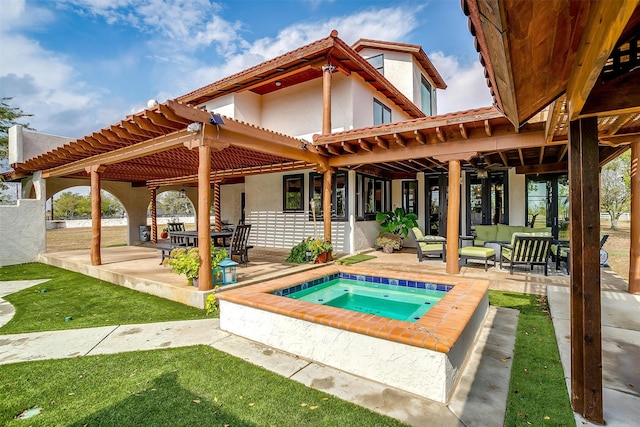 rear view of property featuring a pergola, a patio area, outdoor lounge area, and an in ground hot tub