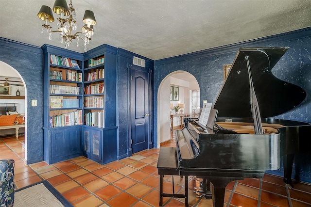 misc room featuring an inviting chandelier, a textured ceiling, tile patterned flooring, and crown molding