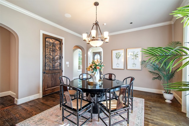 dining space with dark hardwood / wood-style flooring, a chandelier, and crown molding