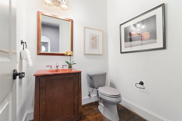 bathroom featuring toilet, vanity, and hardwood / wood-style floors