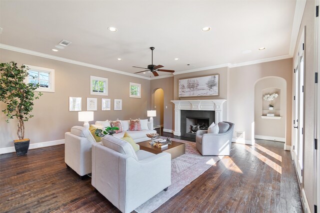 living room featuring dark wood-type flooring, ceiling fan, and crown molding