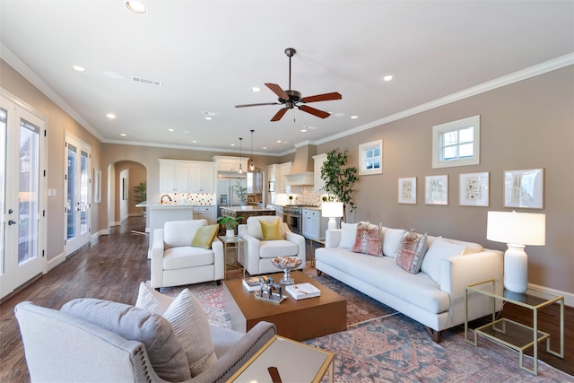 living room with ornamental molding, ceiling fan, and dark hardwood / wood-style floors