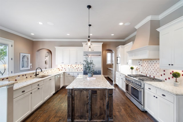 kitchen featuring high quality appliances, sink, decorative light fixtures, and dark hardwood / wood-style flooring