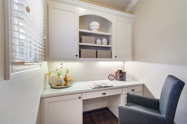 office space featuring built in desk, crown molding, and dark hardwood / wood-style flooring