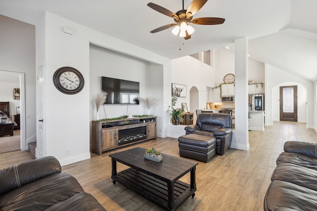 living room featuring high vaulted ceiling, ceiling fan, and light hardwood / wood-style flooring