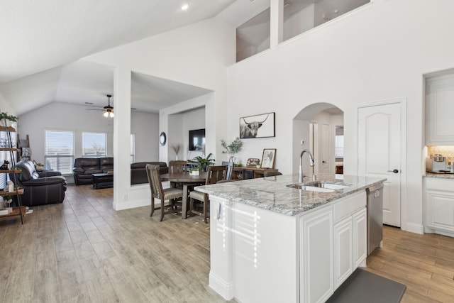 kitchen featuring light hardwood / wood-style flooring, a kitchen island with sink, sink, and white cabinets