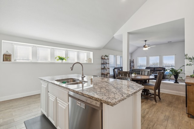 kitchen featuring light wood-type flooring, sink, vaulted ceiling, dishwasher, and a kitchen island with sink