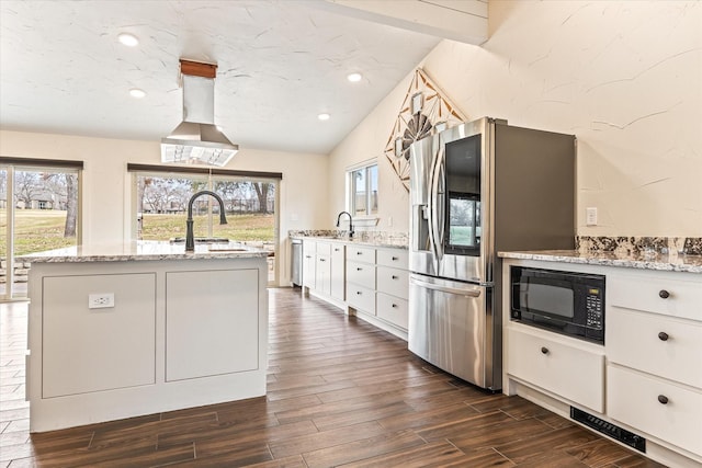 kitchen with white cabinets, island exhaust hood, light stone countertops, and black microwave