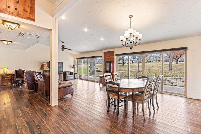 dining room with dark wood-type flooring and ceiling fan with notable chandelier