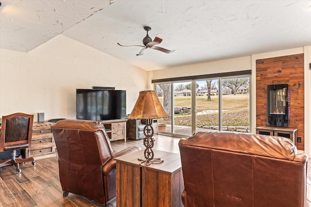 living room with lofted ceiling, ceiling fan, and wood-type flooring