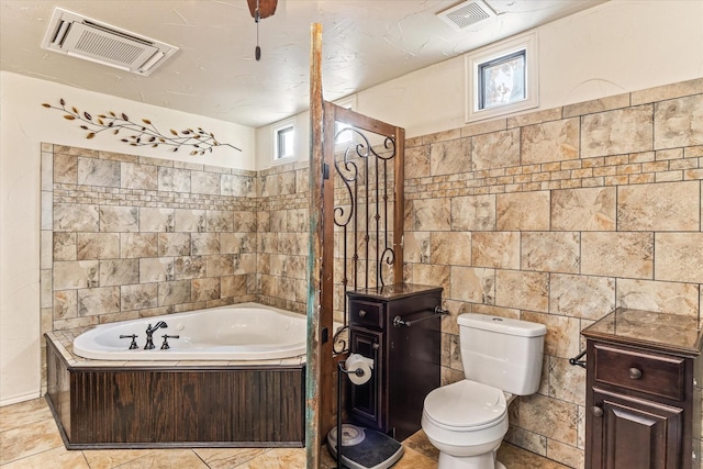 bathroom featuring a bathtub, toilet, and tile walls