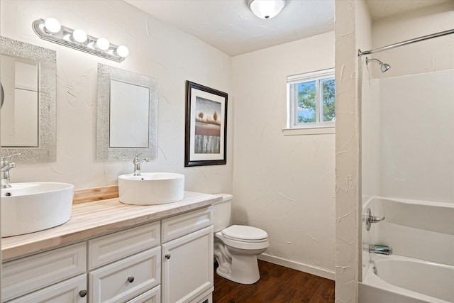 full bathroom featuring hardwood / wood-style floors, vanity, toilet, and shower / washtub combination