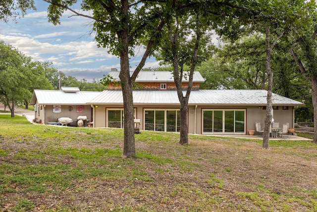 back of property featuring a lawn and a patio