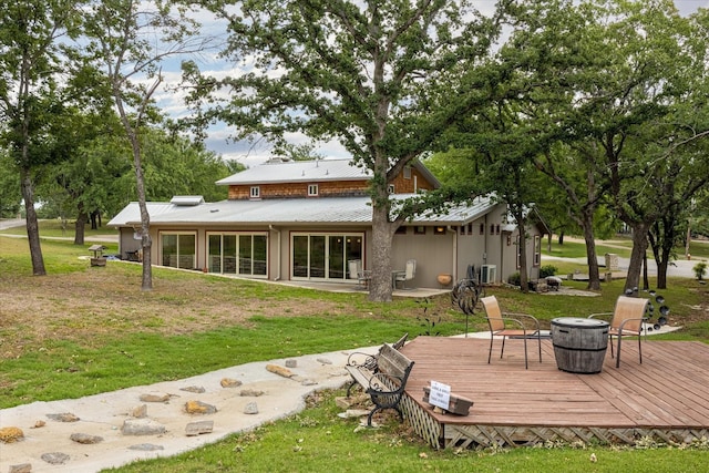 back of house featuring a deck and a lawn