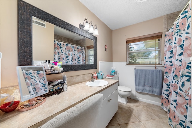 bathroom featuring toilet, vanity, a textured ceiling, and tile patterned floors