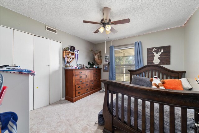 carpeted bedroom with a textured ceiling and ceiling fan