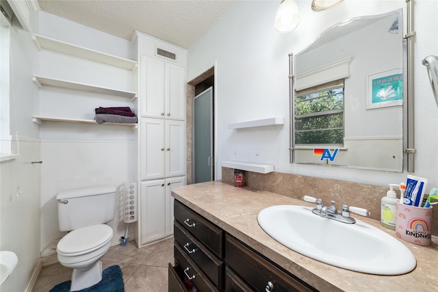 bathroom with a shower with door, tile patterned flooring, a textured ceiling, vanity, and toilet