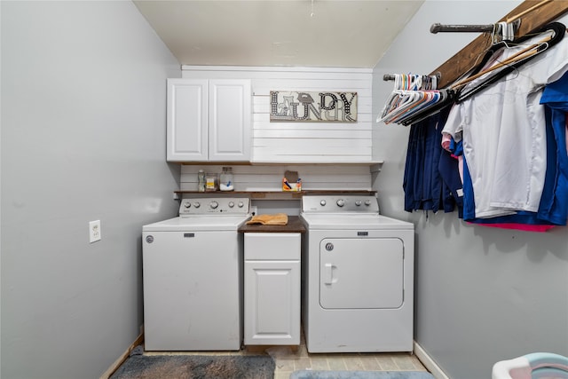 clothes washing area featuring cabinets and washer and dryer