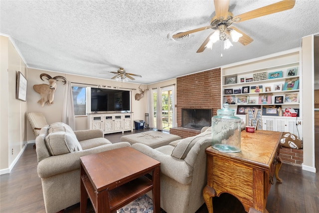 living room with dark wood-type flooring, a textured ceiling, and a brick fireplace