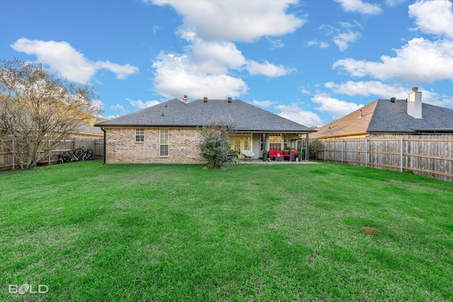 rear view of house with a lawn and a patio area