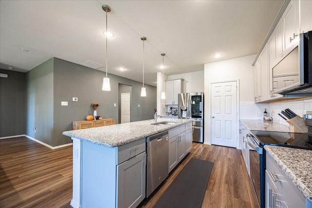 kitchen featuring appliances with stainless steel finishes, a kitchen island with sink, dark wood finished floors, and a sink