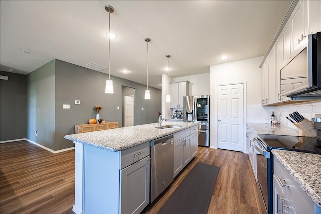 kitchen with appliances with stainless steel finishes, dark wood-style floors, a sink, a kitchen island with sink, and recessed lighting