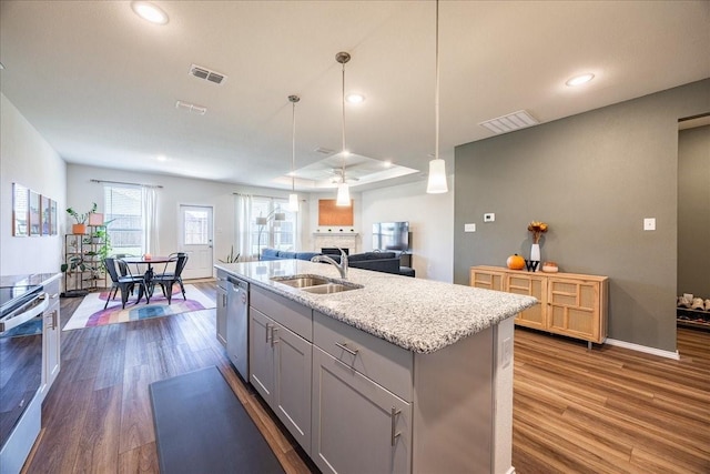 kitchen with dark wood finished floors, gray cabinets, visible vents, appliances with stainless steel finishes, and a sink