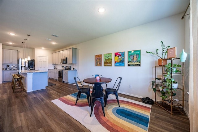 dining area with dark wood-style floors, recessed lighting, visible vents, and baseboards