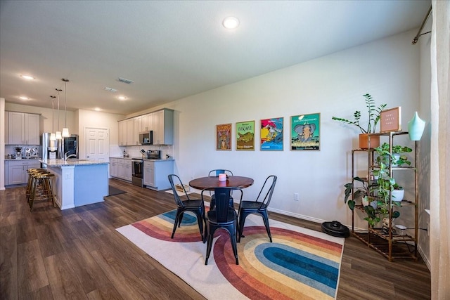 dining room with dark wood-type flooring, recessed lighting, and baseboards